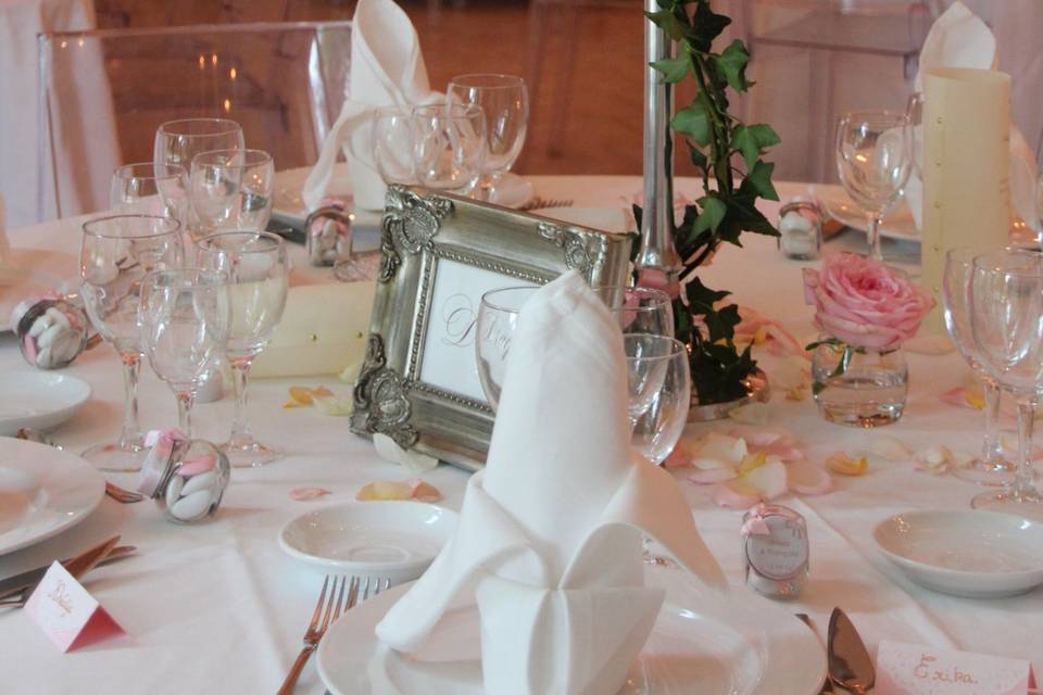 Une table de mariage dressée, roses et argenterie