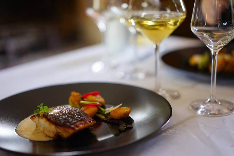 Un plat du dîner, poisson et légumes, avec un verre de vin blanc